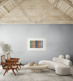Lebanon art print by ENJZ in a white frame, displayed in a raw loft space with exposed timber ceiling, Pierre Jeanneret chairs and a curved cream sofa. Original Arabic poetry by Zein Sourany.